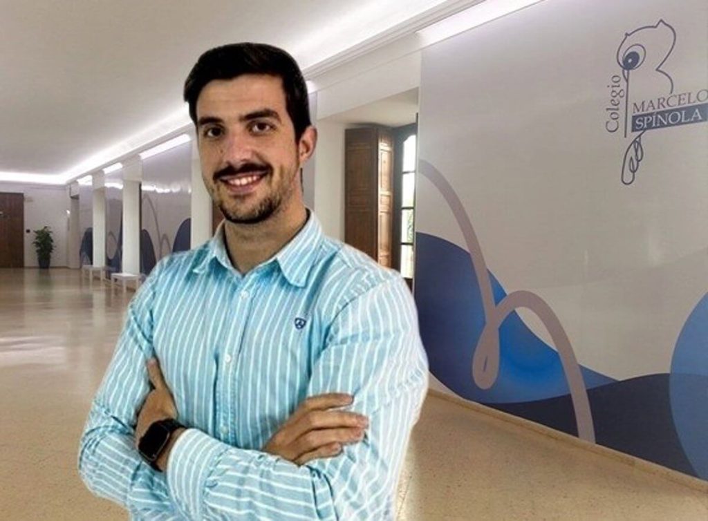 Fotografía del profesor David Horrillo sonriendo con los brazos cruzados en un pasillo del Colegio Marcelo Spínola.